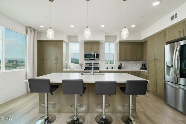2850 Wagon Wheel Rd Unit 402, Oxnard, CA 93036 - kitchen with appliances with stainless steel finishes, healthy amount of natural light, decorative backsplash, light wood-style floors, and recessed lighting
