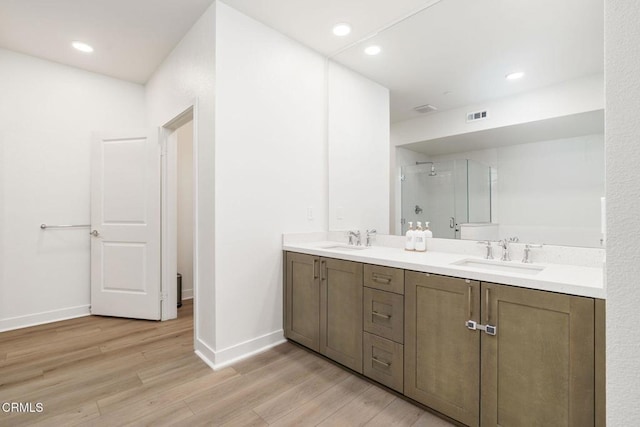 2850 Wagon Wheel Rd Unit 402, Oxnard, CA 93036 - bathroom featuring wood finished floors, a shower stall, double vanity, and recessed lighting