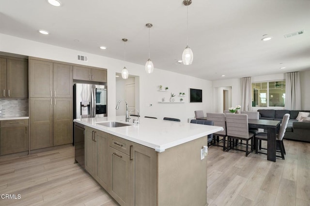 2850 Wagon Wheel Rd Unit 402, Oxnard, CA 93036 - kitchen featuring appliances with stainless steel finishes, light wood-style floors, open floor plan, light countertops, and hanging light fixtures