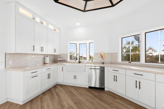 1248 Via Christina, Vista, CA 92084 - kitchen featuring dishwasher, light countertops, backsplash, glass insert cabinets, and light wood-style flooring