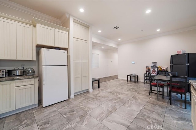 2461 Santa Ana N, Los Angeles, CA 90059 - kitchen with freestanding refrigerator, ornamental molding, light marble finish flooring, recessed lighting, and dark stone countertops
