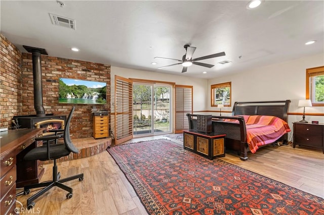 35728 Beauty Vista Ln, Agua Dulce, CA 91390 - bedroom featuring wood finished floors, a wood stove, recessed lighting, access to exterior, and brick wall