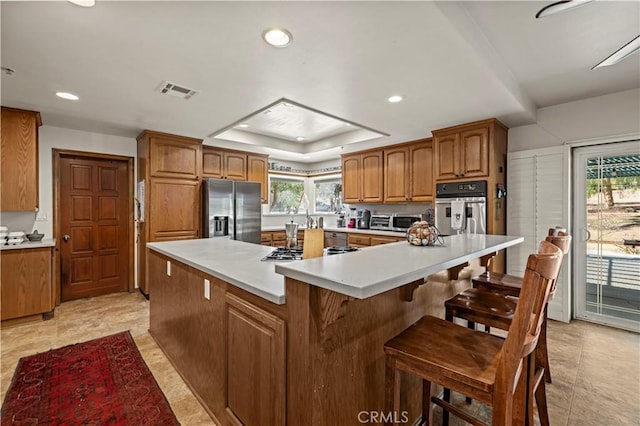 35728 Beauty Vista Ln, Agua Dulce, CA 91390 - kitchen with appliances with stainless steel finishes, brown cabinetry, a raised ceiling, recessed lighting, and light countertops
