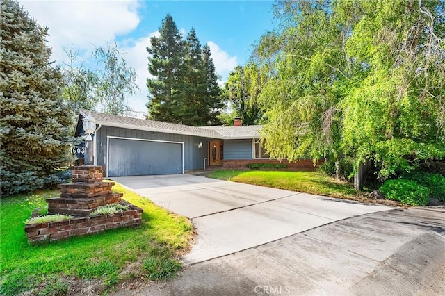 603 Reed Park Dr, Chico, CA 95926 - ranch-style house with an attached garage, concrete driveway, a chimney, and board and batten siding