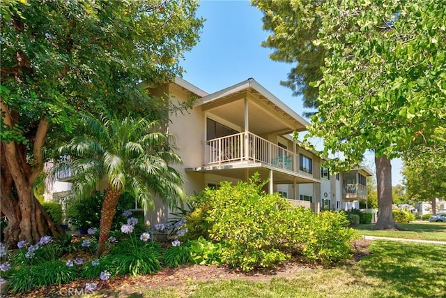 922 Avenida Majorca Unit O, Laguna Woods, CA 92637 - view of home's exterior with a balcony, stucco siding, and a yard