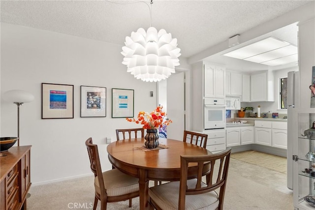 922 Avenida Majorca Unit O, Laguna Woods, CA 92637 - dining space featuring light colored carpet, a textured ceiling, and a chandelier