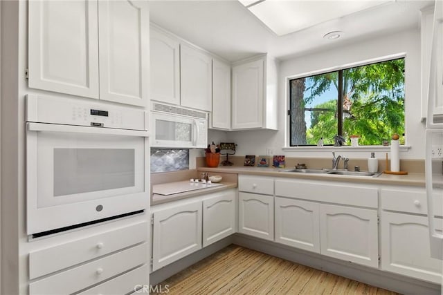 922 Avenida Majorca Unit O, Laguna Woods, CA 92637 - kitchen with white appliances, light countertops, and white cabinetry