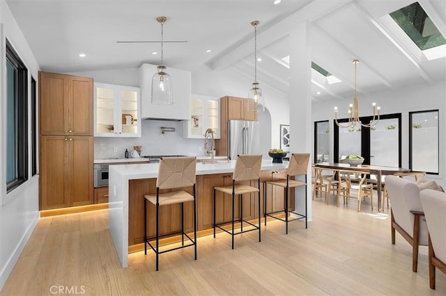 2708 Via Elevado, Palos Verdes Estates, CA 90274 - kitchen featuring freestanding refrigerator, a skylight, light countertops, light wood finished floors, and a large island