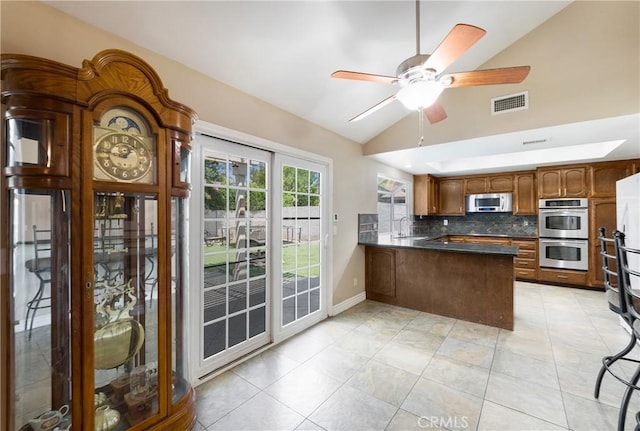 4441 Rustic Rd, Yorba Linda, CA 92886 - kitchen featuring double oven, a peninsula, vaulted ceiling, dark countertops, and a ceiling fan
