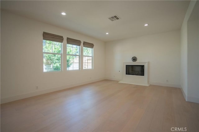 8656 Harvest Pl, Rancho Cucamonga, CA 91730 - unfurnished living room featuring a glass covered fireplace, light wood-style floors, and recessed lighting