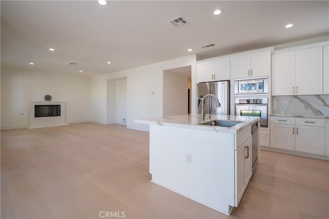 8656 Harvest Pl, Rancho Cucamonga, CA 91730 - kitchen with appliances with stainless steel finishes, recessed lighting, white cabinets, and light wood-style floors