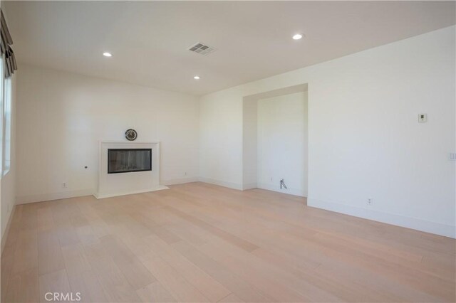 8656 Harvest Pl, Rancho Cucamonga, CA 91730 - unfurnished living room with light wood finished floors, a glass covered fireplace, and recessed lighting