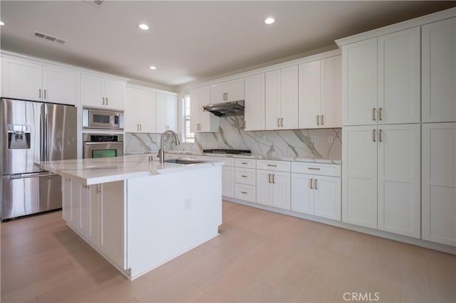 8656 Harvest Pl, Rancho Cucamonga, CA 91730 - kitchen featuring appliances with stainless steel finishes, under cabinet range hood, tasteful backsplash, white cabinets, and recessed lighting