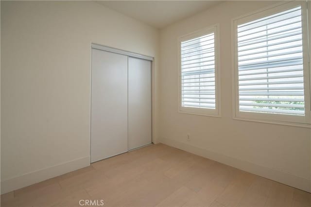 8656 Harvest Pl, Rancho Cucamonga, CA 91730 - unfurnished bedroom with a closet, multiple windows, and light wood-style flooring