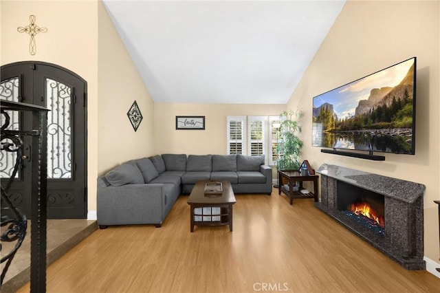 2405 E Alicia St, West Covina, CA 91792 - living room with vaulted ceiling, wood finished floors, a fireplace, and arched walkways