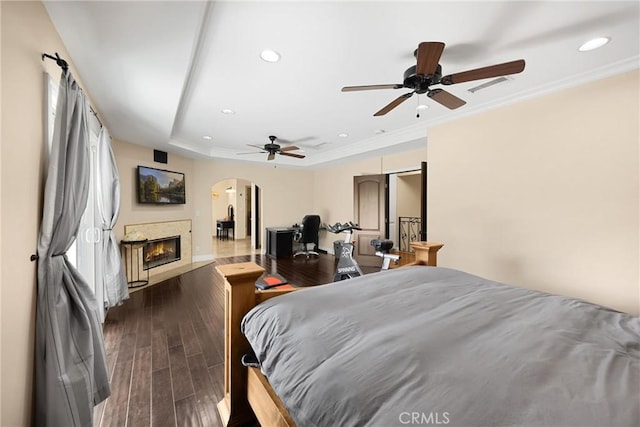 2405 E Alicia St, West Covina, CA 91792 - bedroom with arched walkways, a glass covered fireplace, recessed lighting, dark wood-style floors, and crown molding