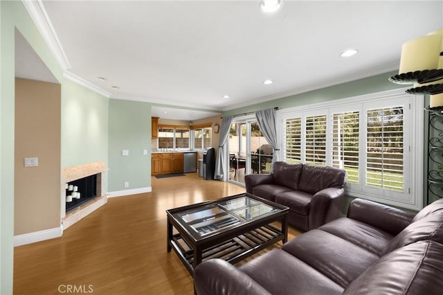 2405 E Alicia St, West Covina, CA 91792 - living area featuring crown molding, light wood-style flooring, recessed lighting, and a multi sided fireplace