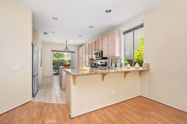 41791 Corte Lara, Temecula, CA 92592 - kitchen with appliances with stainless steel finishes, a peninsula, light wood-style flooring, a breakfast bar, and recessed lighting