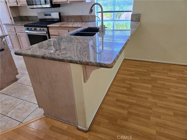 41791 Corte Lara, Temecula, CA 92592 - kitchen featuring stainless steel appliances, light wood-style flooring, a breakfast bar area, and stone counters