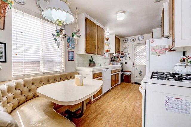 4750 W 191st St, Torrance, CA 90503 - kitchen featuring white appliances, light countertops, light wood-style flooring, decorative backsplash, and brown cabinetry