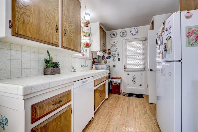 4750 W 191st St, Torrance, CA 90503 - kitchen with white appliances, light wood-type flooring, decorative backsplash, and brown cabinets