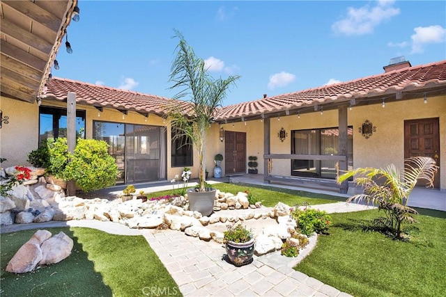 19678 Red Feather Rd, Apple Valley, CA 92307 - back of house with stucco siding, a tiled roof, and a yard