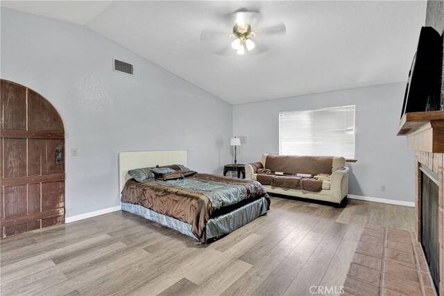 19678 Red Feather Rd, Apple Valley, CA 92307 - bedroom with lofted ceiling, wood finished floors, a fireplace with flush hearth, and a ceiling fan