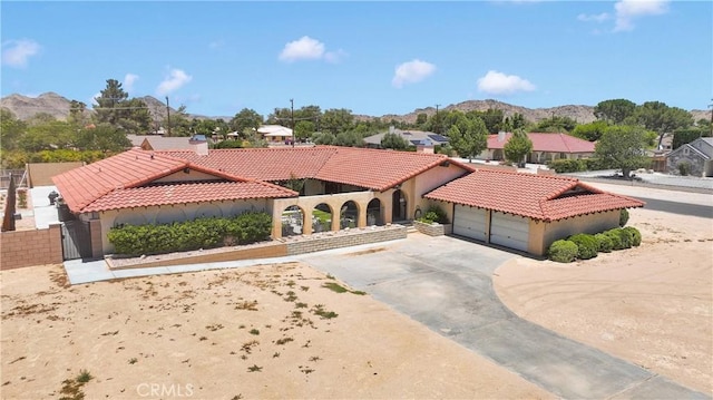 19678 Red Feather Rd, Apple Valley, CA 92307 - mediterranean / spanish-style house featuring a tiled roof, driveway, an attached garage, and stucco siding