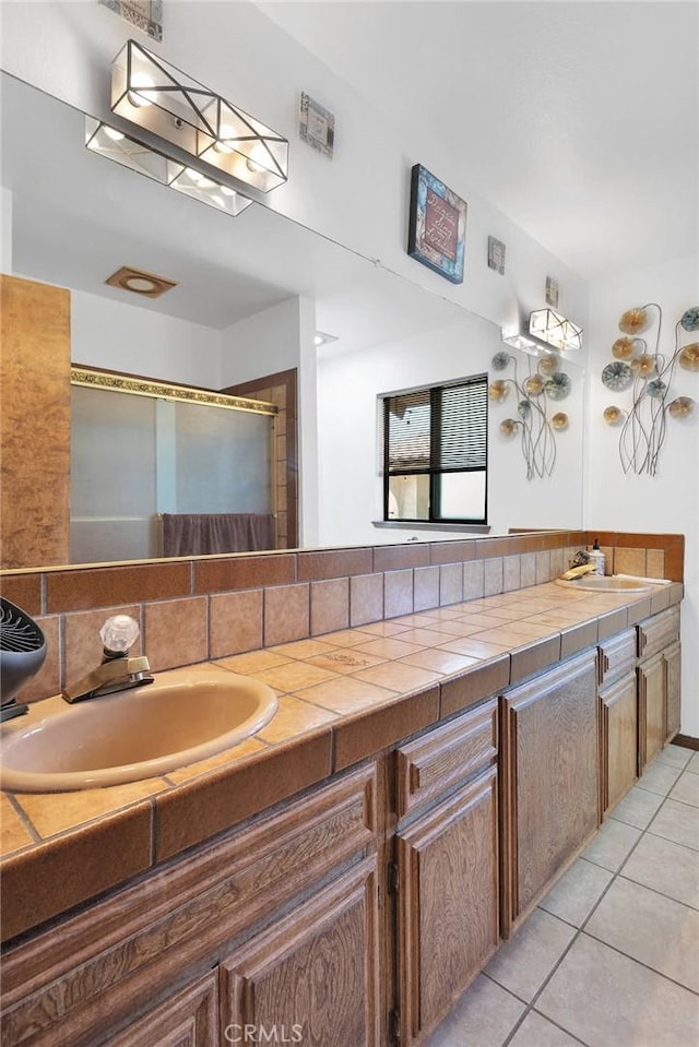 19678 Red Feather Rd, Apple Valley, CA 92307 - full bath with tile patterned floors, double vanity, decorative backsplash, and a shower with shower door