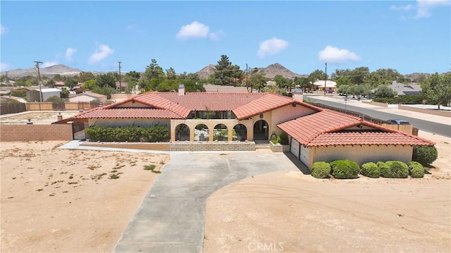 19678 Red Feather Rd, Apple Valley, CA 92307 - mediterranean / spanish house with a tile roof, a mountain view, a chimney, stucco siding, and driveway