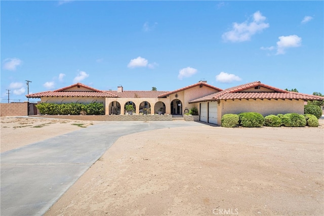 19678 Red Feather Rd, Apple Valley, CA 92307 - mediterranean / spanish home with an attached garage, driveway, stucco siding, and a tiled roof