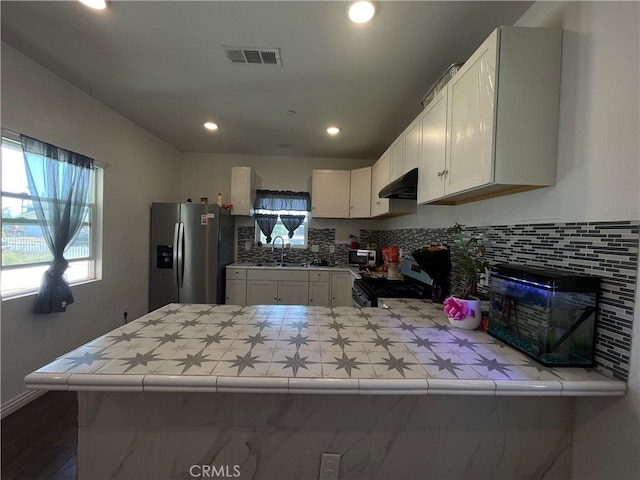 1012 Feliz Dr, Bakersfield, CA 93307 - kitchen with stainless steel appliances, under cabinet range hood, tile countertops, a peninsula, and recessed lighting
