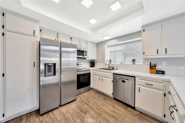 24812 Leto Cir, Mission Viejo, CA 92691 - kitchen featuring stainless steel appliances, a tray ceiling, and white cabinets