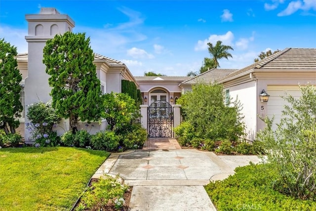 5 Marbella, Dana Point, CA 92629 - view of front of home with stucco siding, a tiled roof, a gate, and a front lawn