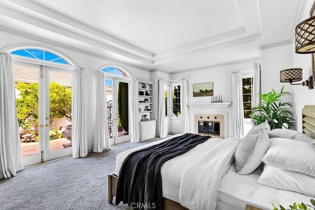 5 Marbella, Dana Point, CA 92629 - carpeted bedroom featuring access to outside, a tray ceiling, and a glass covered fireplace
