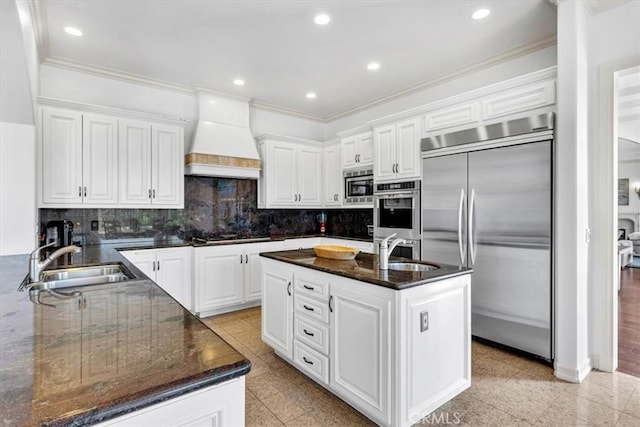 5 Marbella, Dana Point, CA 92629 - kitchen featuring built in appliances, premium range hood, crown molding, white cabinetry, and a kitchen island