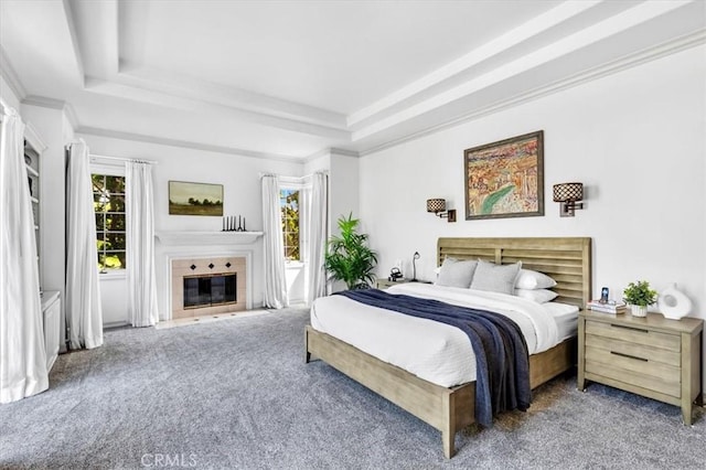 5 Marbella, Dana Point, CA 92629 - carpeted bedroom featuring multiple windows, a tray ceiling, a tile fireplace, and ornamental molding