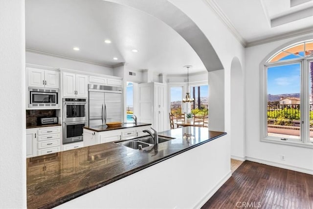 5 Marbella, Dana Point, CA 92629 - kitchen with built in appliances, white cabinets, crown molding, a kitchen island, and dark wood-style floors