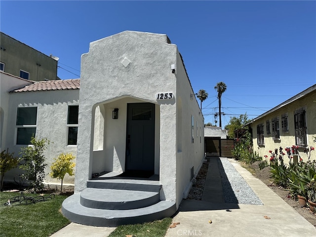 1253 W 65th St, Los Angeles, CA 90044 - view of front facade with stucco siding and a tiled roof