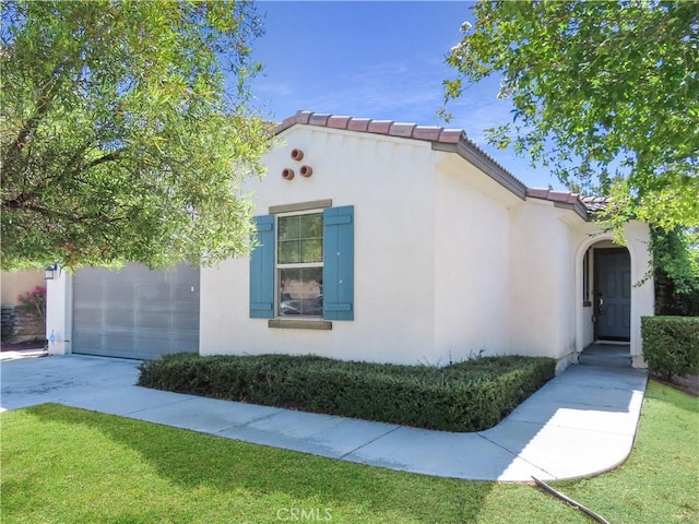29348 Tournament, Lake Elsinore, CA 92530 - view of side of home featuring stucco siding, a tile roof, concrete driveway, and a lawn