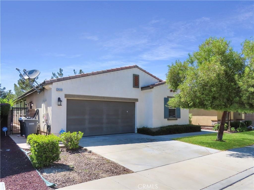 29348 Tournament, Lake Elsinore, CA 92530 - mediterranean / spanish-style home with a garage, driveway, and stucco siding