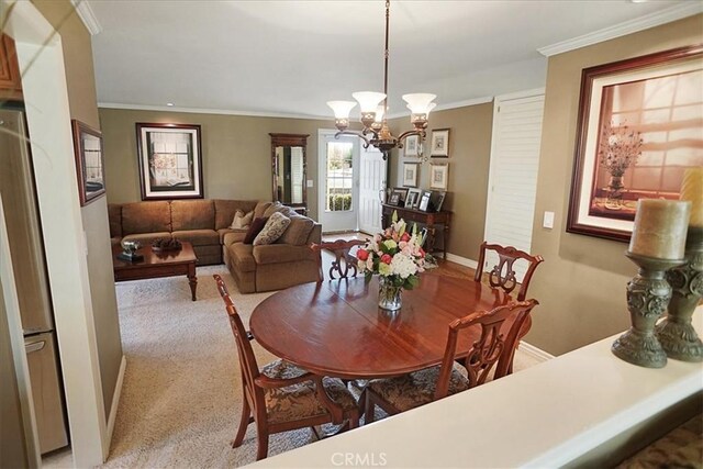 22669 Pamplico Dr, Saugus, CA 91350 - dining room with a chandelier, ornamental molding, and light colored carpet