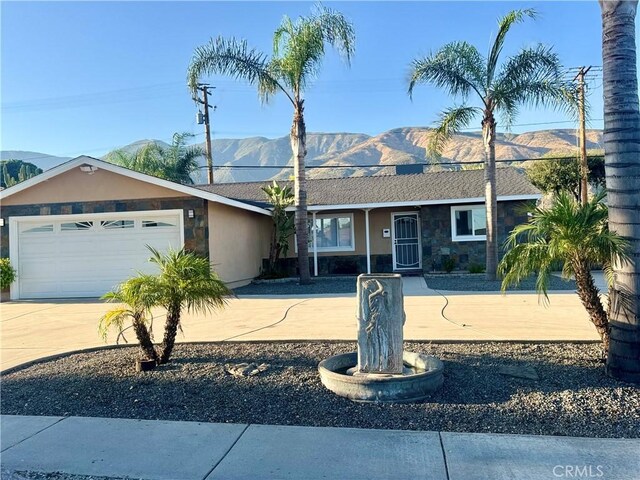 604 Sequoia St, San Bernardino, CA 92407 - ranch-style house featuring a mountain view, driveway, stone siding, an attached garage, and stucco siding
