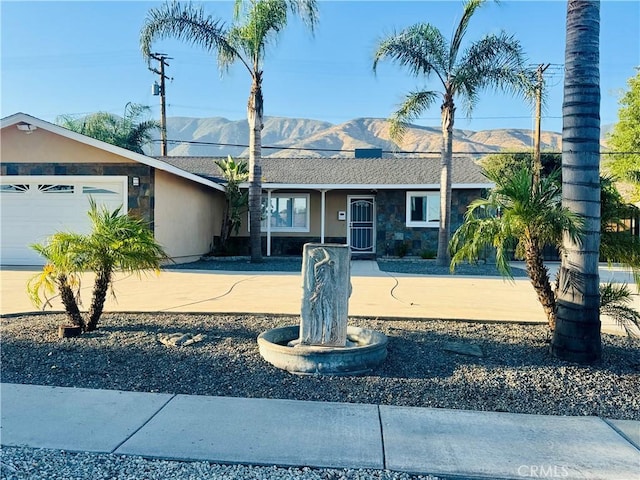 604 Sequoia St, San Bernardino, CA 92407 - single story home featuring a mountain view, an attached garage, concrete driveway, and stone siding