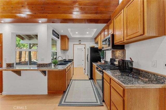 604 Sequoia St, San Bernardino, CA 92407 - kitchen featuring appliances with stainless steel finishes, light wood-type flooring, a kitchen bar, recessed lighting, and a peninsula