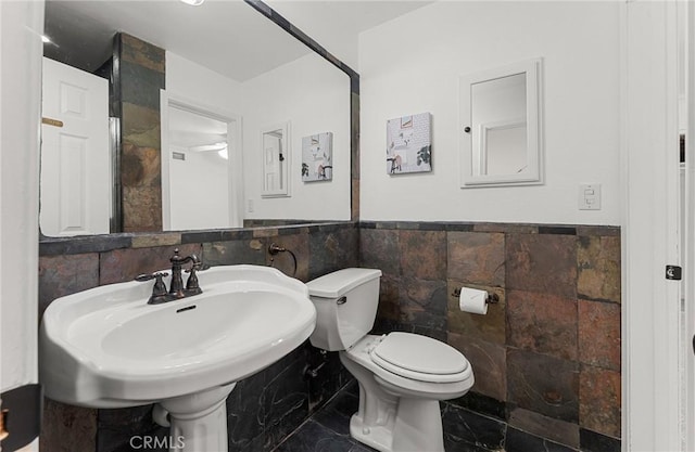 604 Sequoia St, San Bernardino, CA 92407 - half bath featuring tile walls, a wainscoted wall, and marble finish flooring