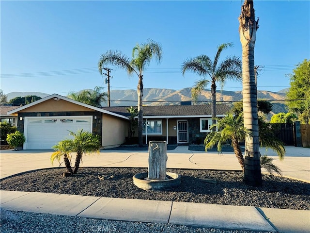 604 Sequoia St, San Bernardino, CA 92407 - single story home with an attached garage, concrete driveway, a mountain view, and stucco siding