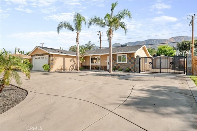 604 Sequoia St, San Bernardino, CA 92407 - ranch-style home featuring driveway, a gate, stone siding, and a mountain view