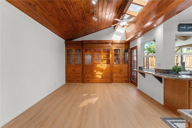 604 Sequoia St, San Bernardino, CA 92407 - kitchen featuring a skylight, light wood-style flooring, dark countertops, lofted ceiling, and wooden ceiling