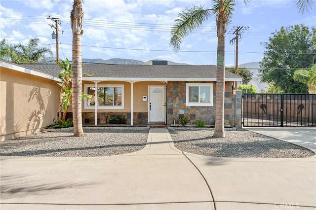 604 Sequoia St, San Bernardino, CA 92407 - single story home with stone siding, a gate, roof with shingles, a mountain view, and stucco siding